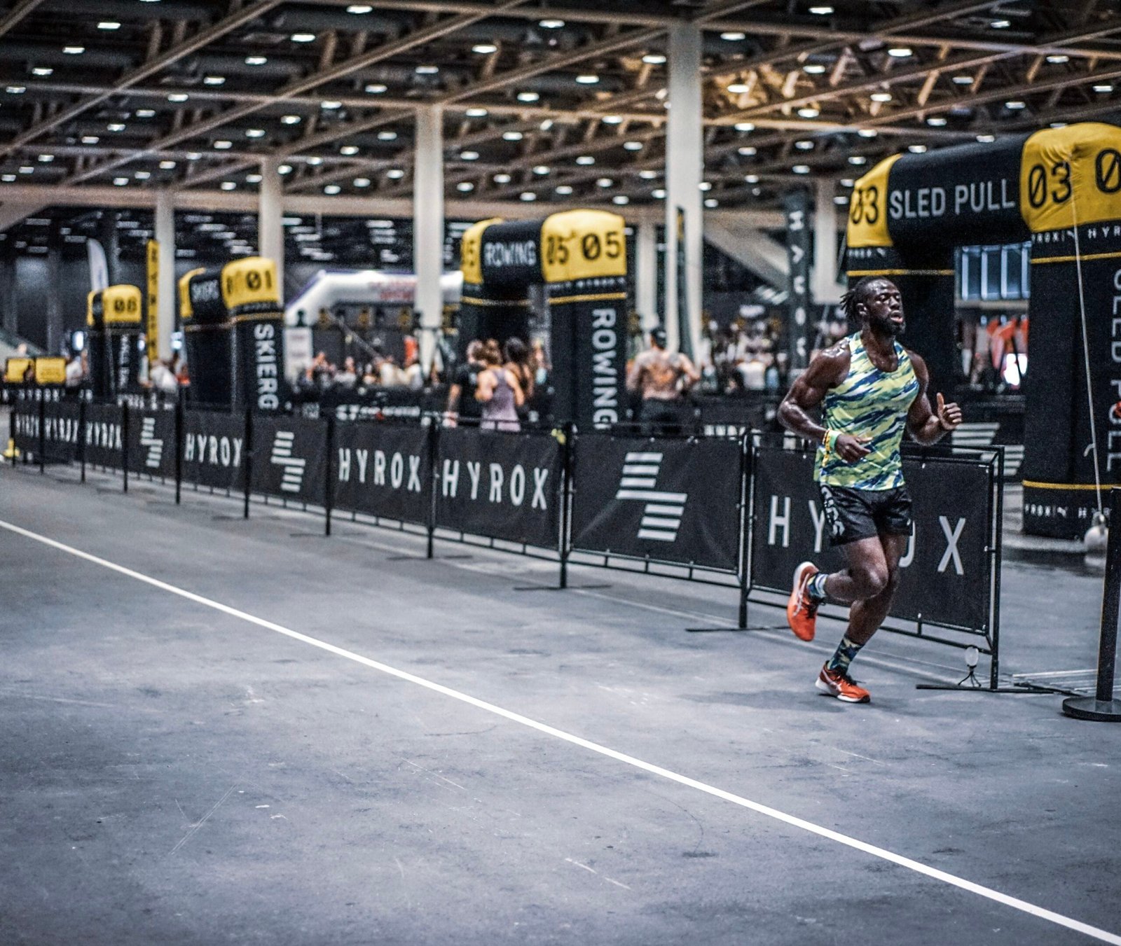 Athlete running through an indoor HYROX race venue